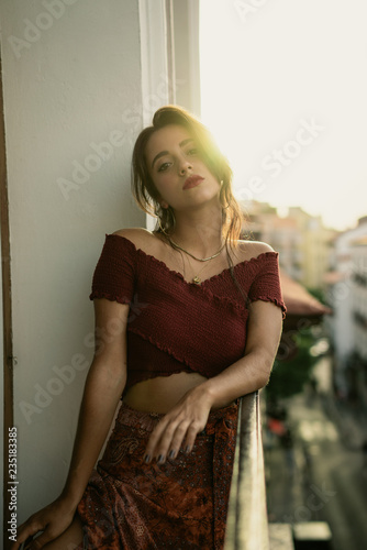 Charming young brunette lady on balcony