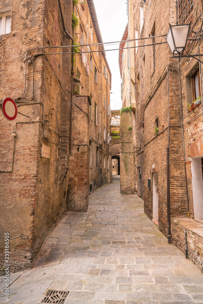 Seitenstraße Pflastersteine mit Ziegelhäuser in der Altstadt von Siena Italien