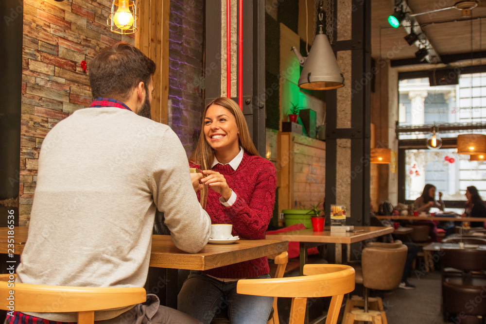 Man giving a present to his girlfriend in cafe and she is surprise Man giving a present to his girlfriend in cafe and she is surprise