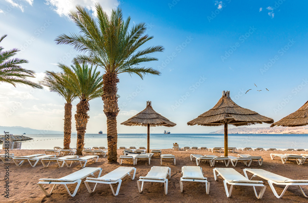 Relaxing  atmosphere on central public beach of Eilat - famous tourist resort  and recreational city in Israel. Concept of healthy vacation