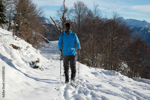 Person with snowshoeing hiking during a sunny day in the italian alps