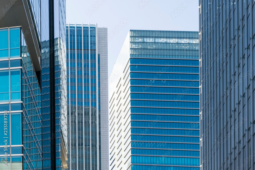 Abstract modern urban blue and gray background featuring details of modern skyscrapers in financial downtown Tokyo, Japan. Abstract modern urban blue and gray background featuring details of modern skyscrapers in financial downtown Tokyo, Japan.