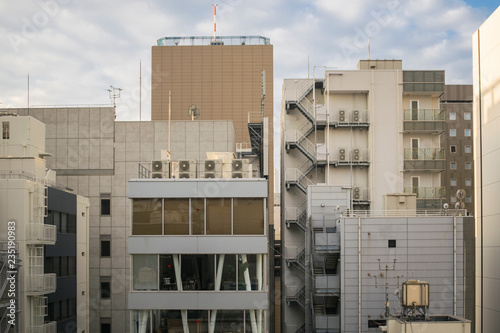 Japanese abstract urban background featuring details of chaotic city buildings in Tokyo downtown in Ginza district at sunrise in November.   