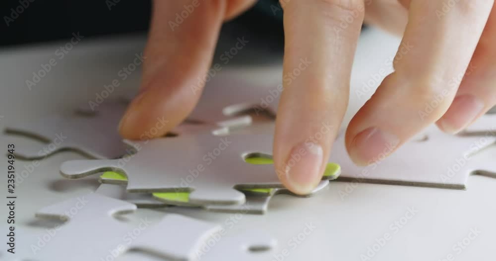 Female hands looking for a specific jigsaw puzzle piece. Chroma key compositing possible. Female hands looking for a specific jigsaw puzzle piece. Chroma key compositing possible.