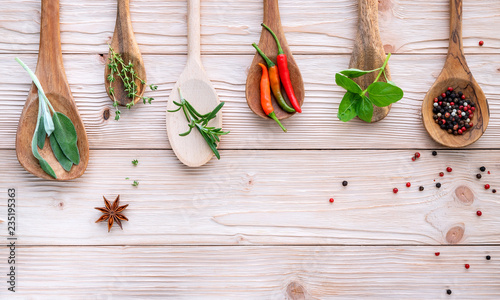Various of spices and herbs in wooden spoons. Flat lay spices ingredients chili ,peppercorn, rosemarry, thyme,star anise ,sage leaves and sweet basil on shabby wooden.