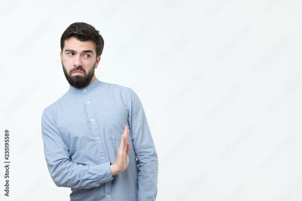 Attractive spanish man with beard shows refusal gesture, e, has sad expression. I do not need this option. Attractive spanish man with beard shows refusal gesture, e, has sad expression. I do not need this option.