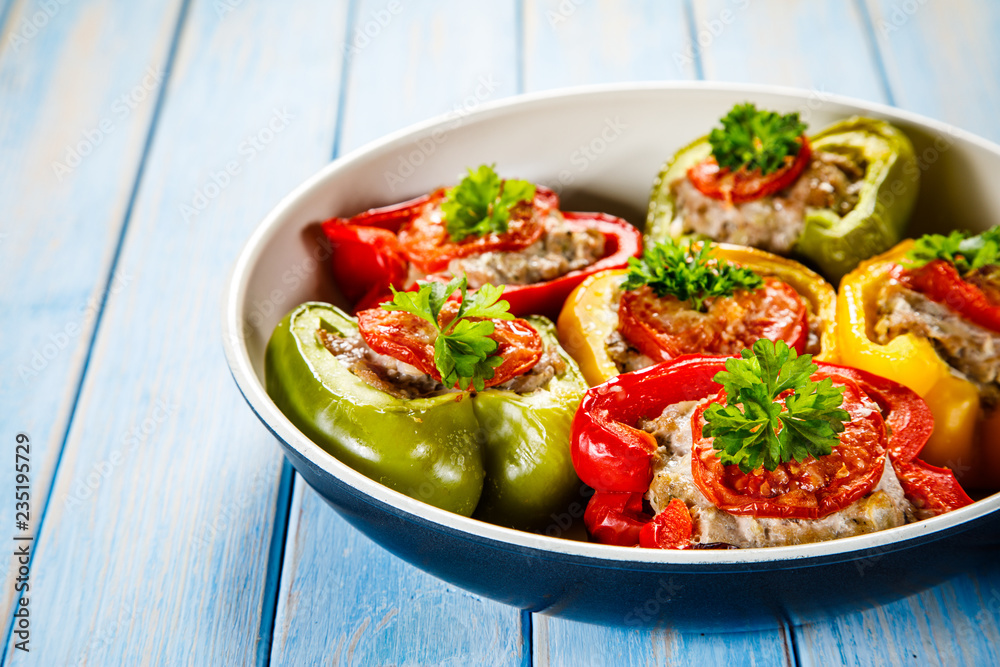 Stuffed peppers in frying pan on wooden table Stuffed peppers in frying pan on wooden table