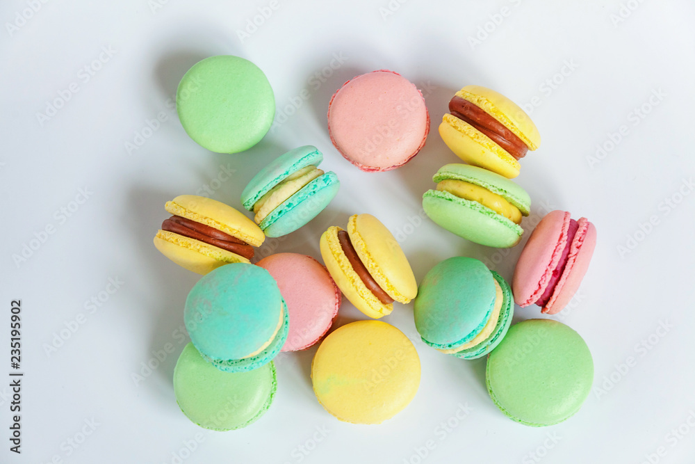 Sweet almond colorful pink, blue, yellow, green macaron or macaroon dessert cake isolated on white background. French sweet cookie. Minimal food bakery concept. Flat lay, top view, copy space Sweet almond colorful pink, blue, yellow, green macaron or macaroon dessert cake isolated on white background. French sweet cookie. Minimal food bakery concept. Flat lay, top view, copy space