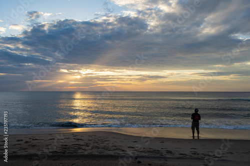 silhouette of young man enjoying the sunrise on virginia beach