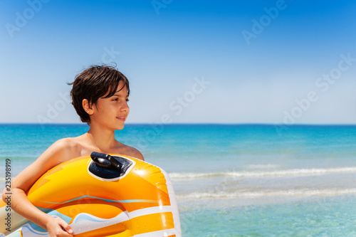 Wistful boy portrait against beautiful seascape during vacations