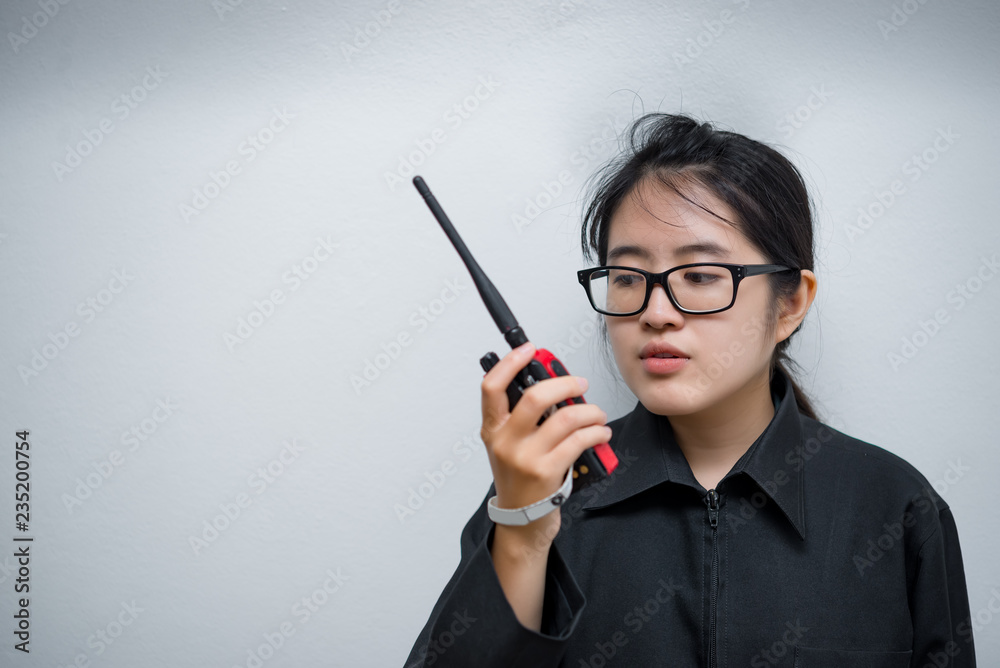 Asian engineer woman wearing glasses,using radio communication on white background,thailand technician use walkie talkie for work Asian engineer woman wearing glasses,using radio communication on white background,thailand technician use walkie talkie for work