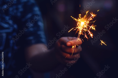 Christmas, New year sparkler in woman hands.