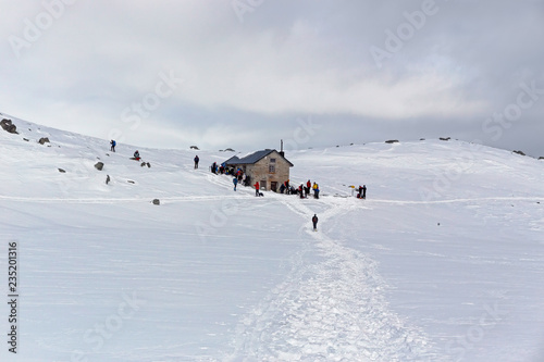 Some snowshoe hikers walk through the snow-covered Alps in winter in the canton of Graubünden in Switzerland.