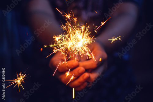 Woman hand holding a burning sparkler, Christmas and new year sparkler holiday background photo