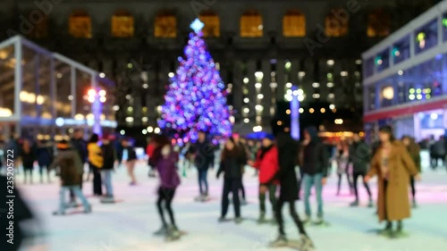 people ice skating with chrismtmas tree on ice ring