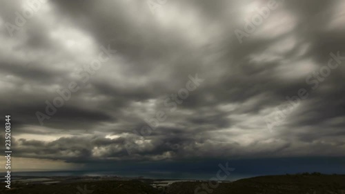 Timelapse of gray winter rain clouds crossing the sky above the ocean or  sea