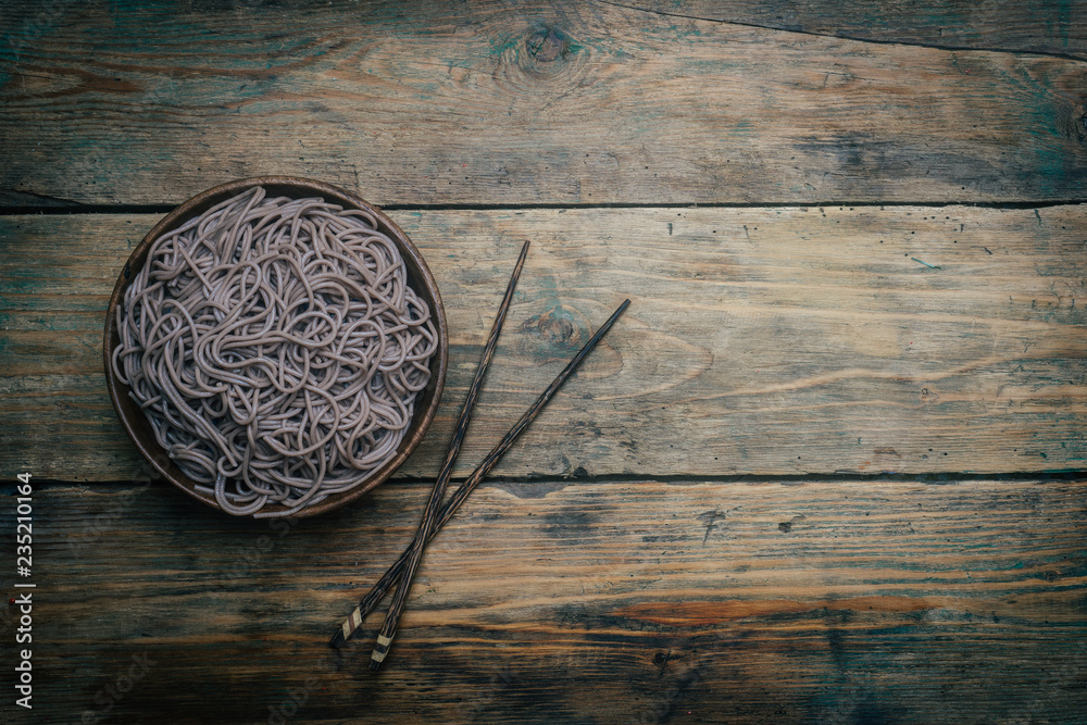 Soba noodles in a wooden bowl on a wooden background. Japanese style. Zen food. Copy space. Soba noodles in a wooden bowl on a wooden background. Japanese style. Zen food. Copy space.