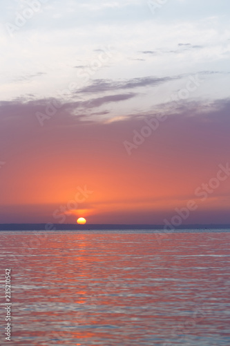 early sunrise morning landscape / the sun rising over the water
