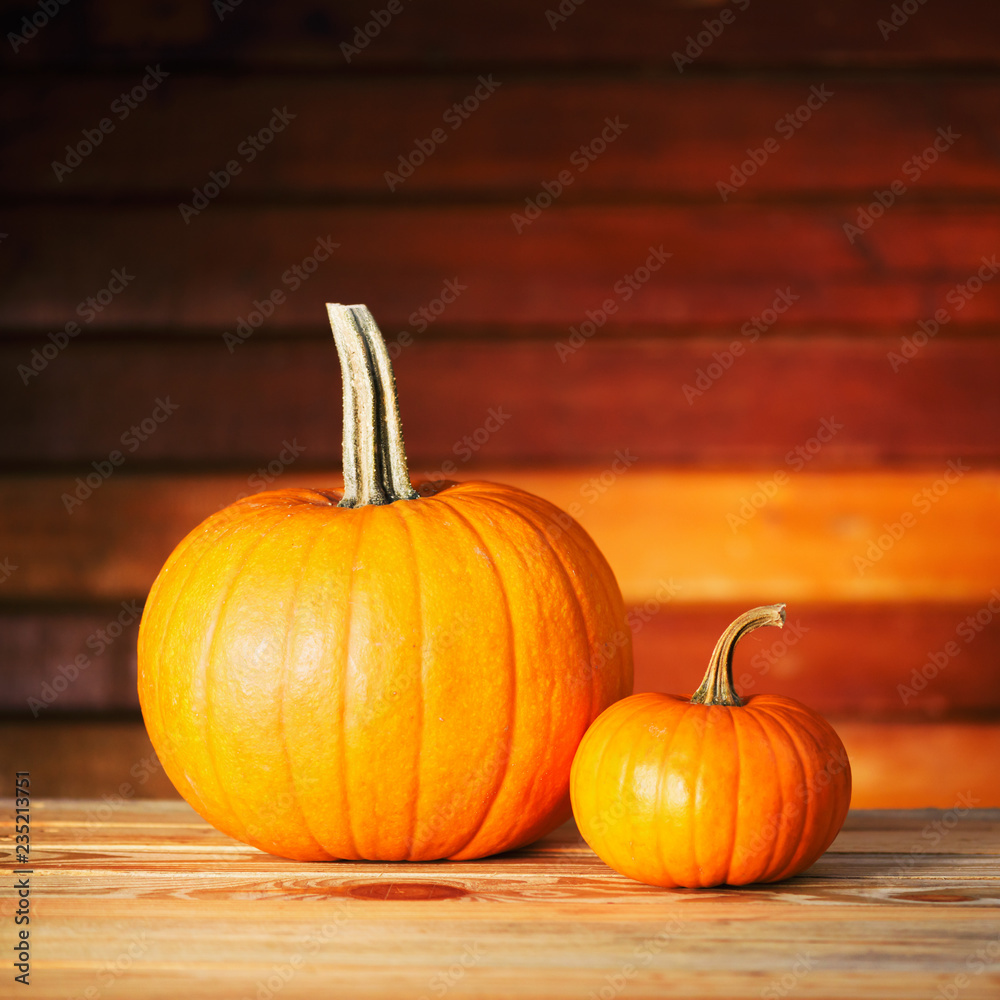 Two pumpkins on wooden table. Halloween and autumn food background Two pumpkins on wooden table. Halloween and autumn food background