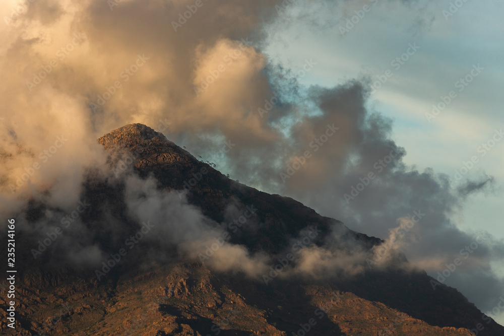 A mountain scene with cloudy sky at sunset.