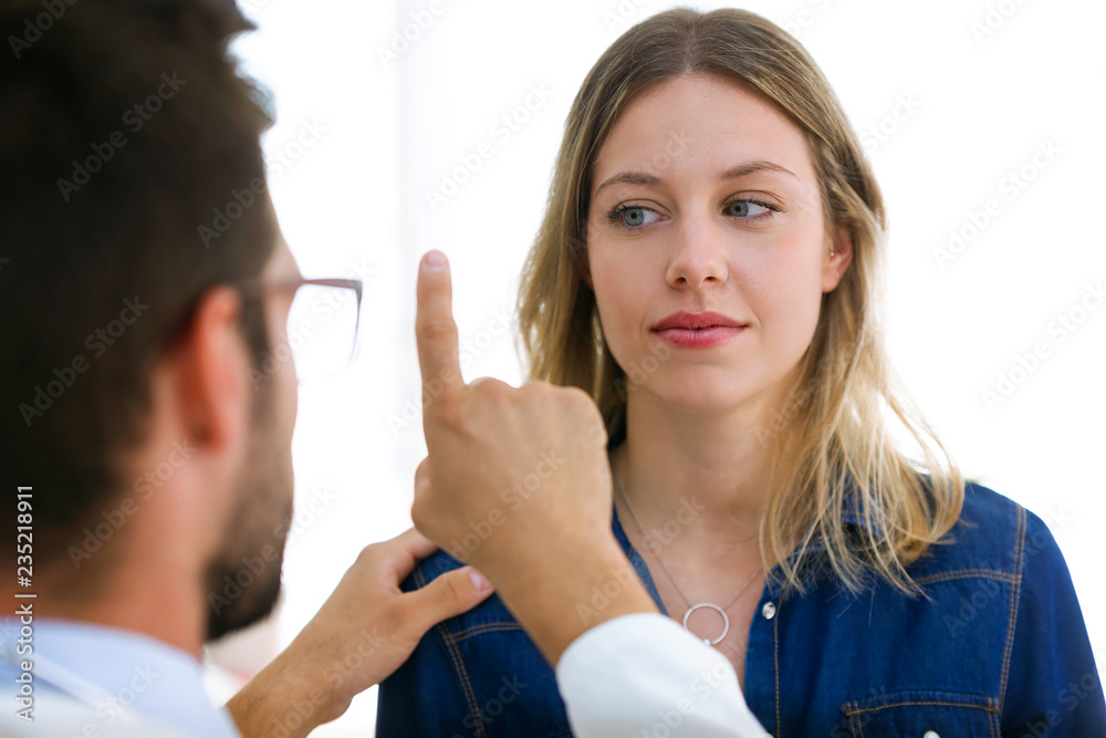 Attractive male doctor ophtalmologist checking the eye vision of beautiful young woman in modern clinic. Attractive male doctor ophtalmologist checking the eye vision of beautiful young woman in modern clinic.