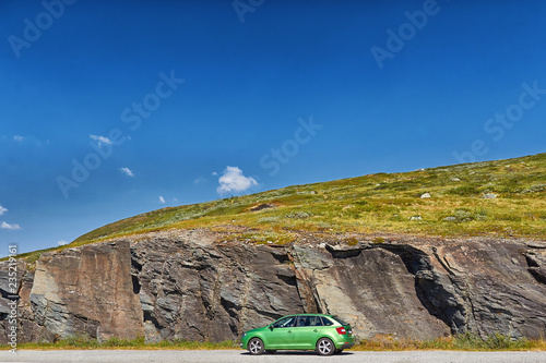 Fototapeta Naklejka Na Ścianę i Meble -  Auto steht an der straße mit Berg im Hintergrund