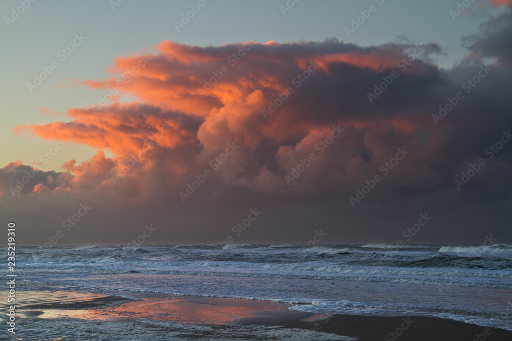 Storm front approaching over the sea after sunset: threatening red clouds above the dark water