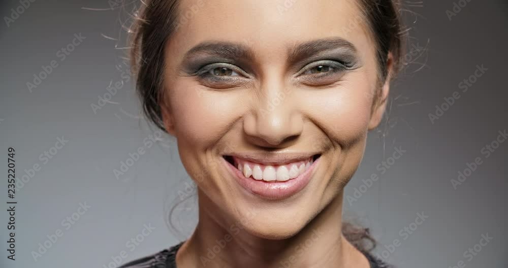 Young asian model with bright make-up and pink lipstick on lips smiling with a charming smile and blinking - extreme closeup 4k Young asian model with bright make-up and pink lipstick on lips smiling with a charming smile and blinking - extreme closeup 4k