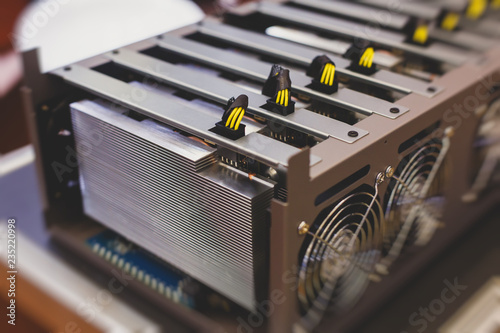 Close-up view of equipment for bitcoin cryptocurrency mining farm, electronic devices with fans, concept of mining technology photo