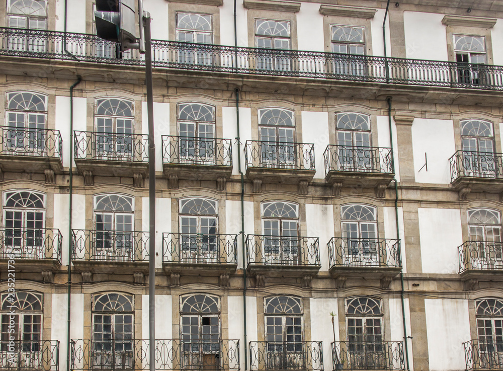 fragment of the wall of an old tenement house with windows in the city of Porto, Portugal