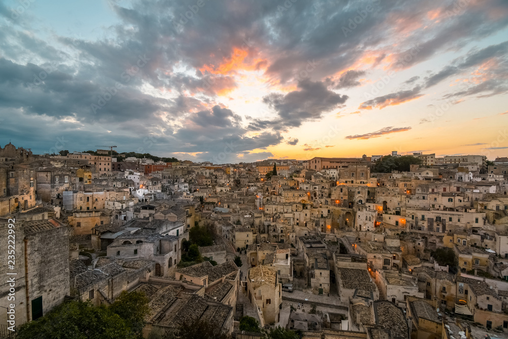 Night approaches as the sun sets in the Puglia region as the the ancient homes, sassi and abandoned buildings fill the hillside of Matera, Italy.