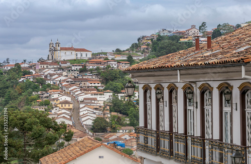 Casarão colonial no centro histórico de Ouro Preto, em primeiro plano, e Igreja de Santa Ifigênia ao fundo com casario em ladeira abaixo, Brasil photo