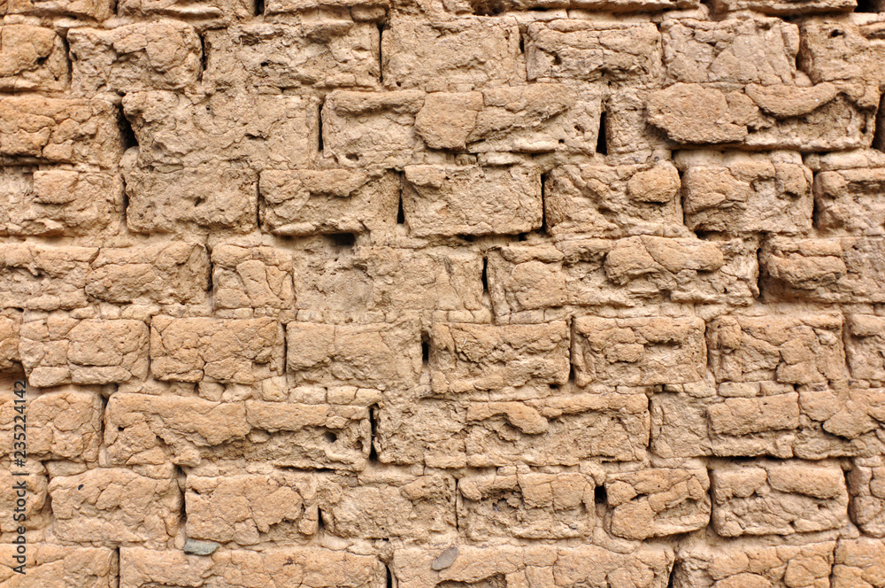 Weathered wall of a house built of bricks from clay.