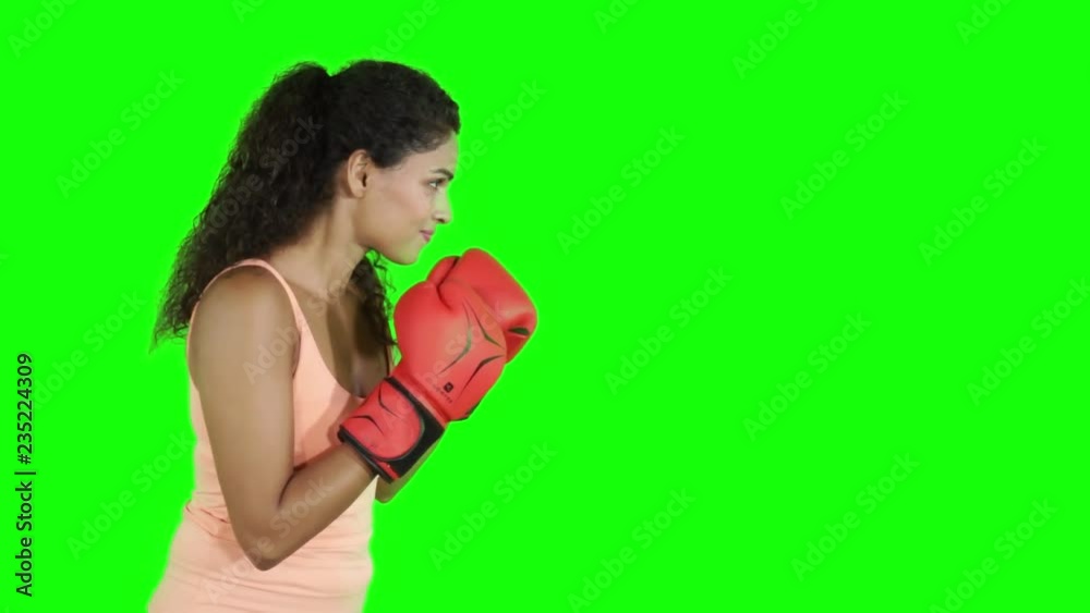Attractive young woman doing boxing exercise in the studio with green screen background Attractive young woman doing boxing exercise in the studio with green screen background