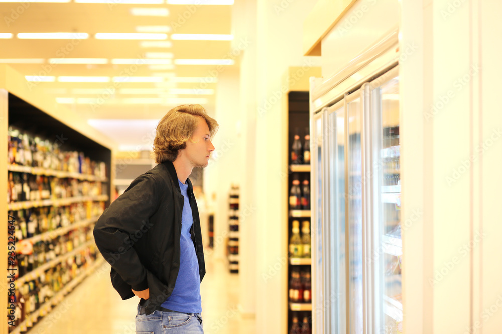 Fototapeta premium Man choosing frozen food from a supermarket freezer.