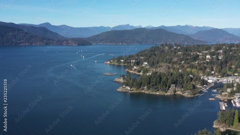 Aerial view over Burrard Inlet, ocean and island with boat and mountains in beautiful British Columbia. Canada. Aerial view over Burrard Inlet, ocean and island with boat and mountains in beautiful British Columbia. Canada.