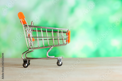 Small shopping cart over light green blur background