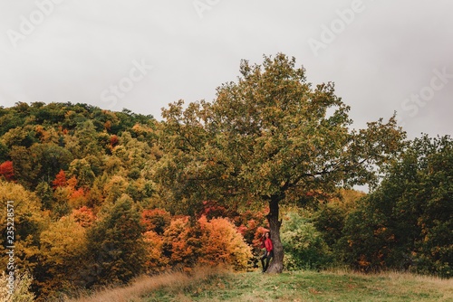 Beautiful girl in red leather jacket in autumn forest.