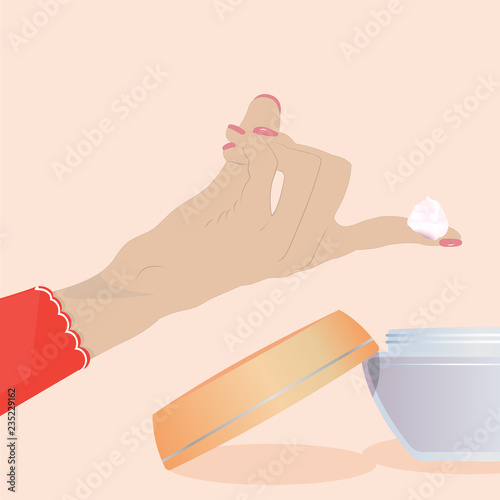 The woman's hand holds a skin cream from the  jar on her fingers