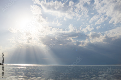 Sea water on cloudy day  nature background . The rays of the sun break through the clouds. Ocean view on cloudy summer day