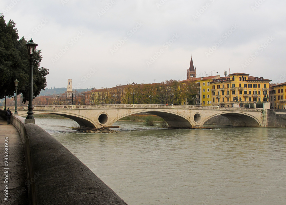 Obraz premium Old historical bridge Ponte della Vittoria across the Adige River in the center of Verona.