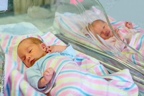 newborn twins boy and girl in hospital under blankets