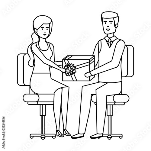 business couple sitting in chairs giving gift