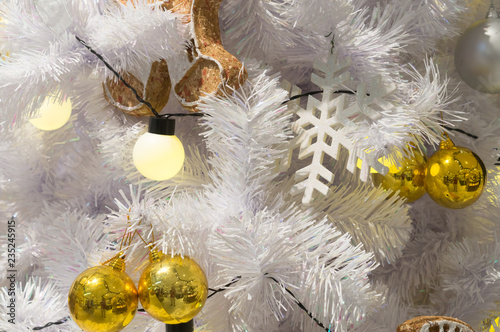 White Christmas tree decoration with metal balls, bauble and blurred background