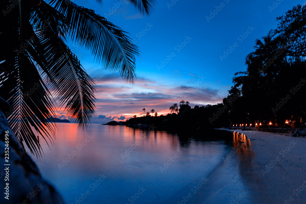 Bright colorful sunset on a tropical island, with silhouettes of palm trees, background and wallpaper, postcard, Koh Phangan island Thailand