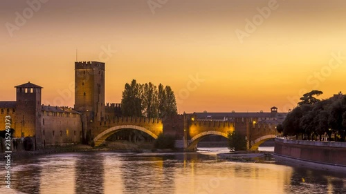 4K footage of The Castel Vecchio Bridge or Scaliger Bridge (Ponte Scaligero) is a fortified bridge in Verona City in Italy, sunset timelapse video day to night. Adige River. photo