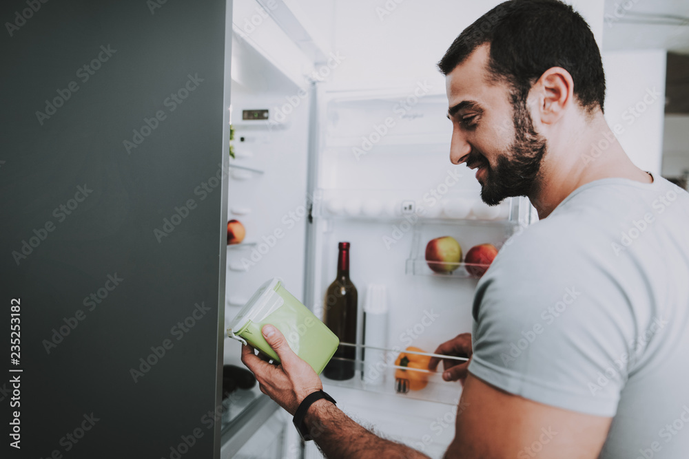 A Sporty Man Takes Vegetables From The Fridge. A Sporty Man Takes Vegetables From The Fridge.