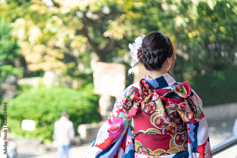 Young girl wearing Japanese kimono standing in front of Sensoji Temple in Tokyo, Japan. Kimono is a Japanese traditional garment. The word Young girl wearing Japanese kimono standing in front of Sensoji Temple in Tokyo, Japan. Kimono is a Japanese traditional garment. The word
