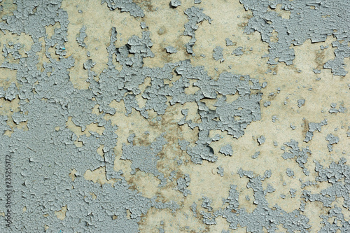 grey peeling paint on the old rough concrete surface