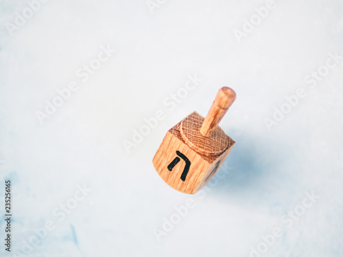 Jewish holiday Hanukkah concept and background. Hanukkah traditional spinnig dreidl or dredel on blue background. Copy space for text. Top view or flat lay. photo
